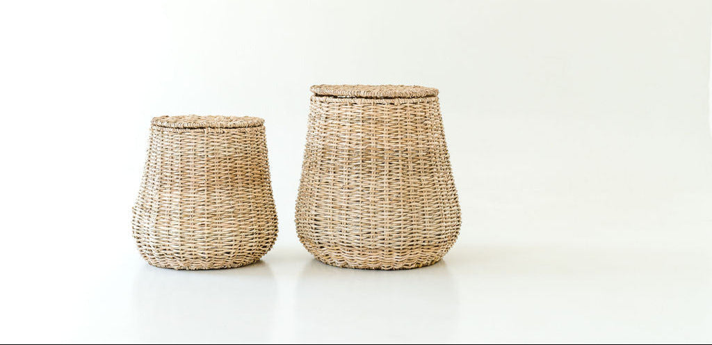 Two woven baskets with lids on a white background